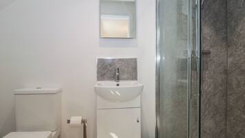 Ein modernes Badezimmer mit Toilette, Waschbecken und Duschkabine.