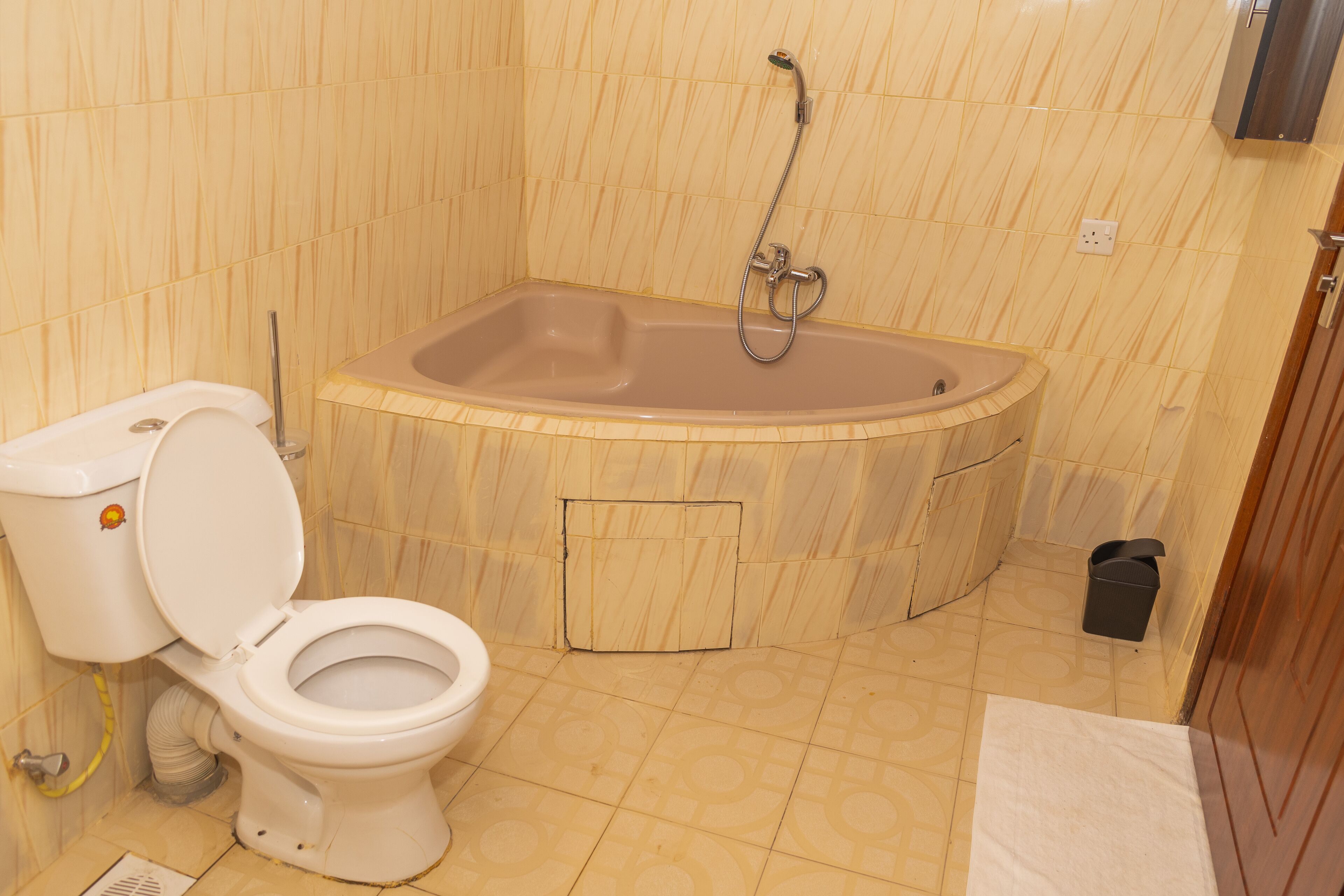 A bathroom with a toilet, a bathtub, and a shower.