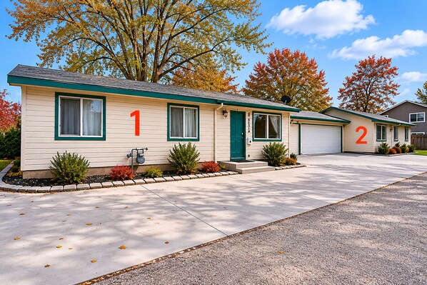 A two-story mobile home with numbered doors, a front porch, and a driveway. - Two Adjacent Apartments for Large Groups (3539) (Boise)