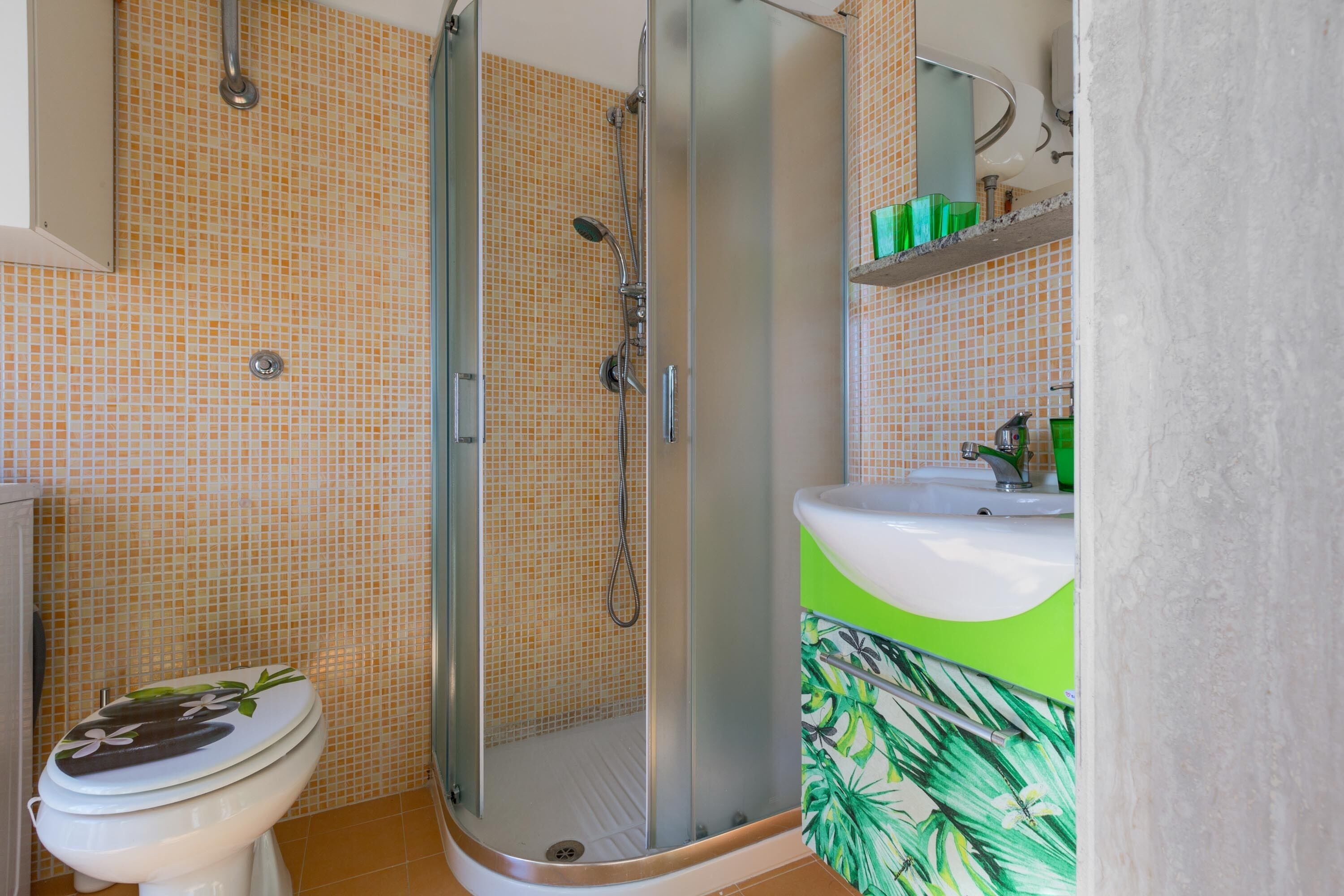 A bathroom with a shower, toilet, and sink.