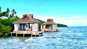 Two wooden overwater bungalows with open sides, connected by a bridge, situated on a calm sea with clear skies. - Full Moon Private Island (Kiri Sakor)