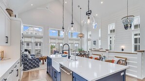 A spacious kitchen with a large island, pendant lighting, and a view of the outdoors. - Pet-Friendly, Pool-Side Beach Home@Cinnamon Shore W/20+ Resort-Like Amenities (Port Aransas)