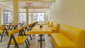 Een restaurant met gele zitplaatsen, marmeren vloeren en een modern plafondontwerp.