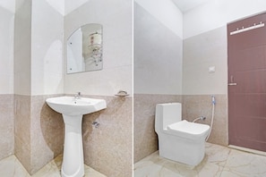 A bathroom with a pedestal sink, a toilet, and a mirror on the wall. - Chaudhary Guest House (Dehradun)