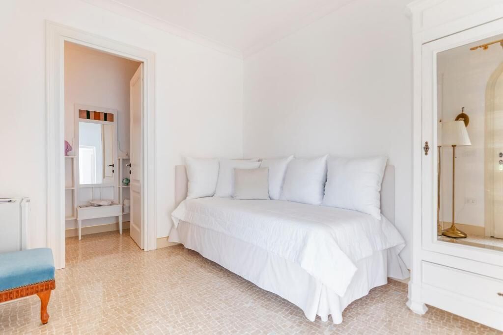 Camera da letto con un letto grande, un comodino, una sedia e un armadio.