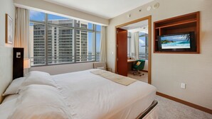 A hotel room with a large bed, a television mounted on the wall, and a view of high-rise buildings through the window. - Miami Luxury Executive Apartment (Miami)