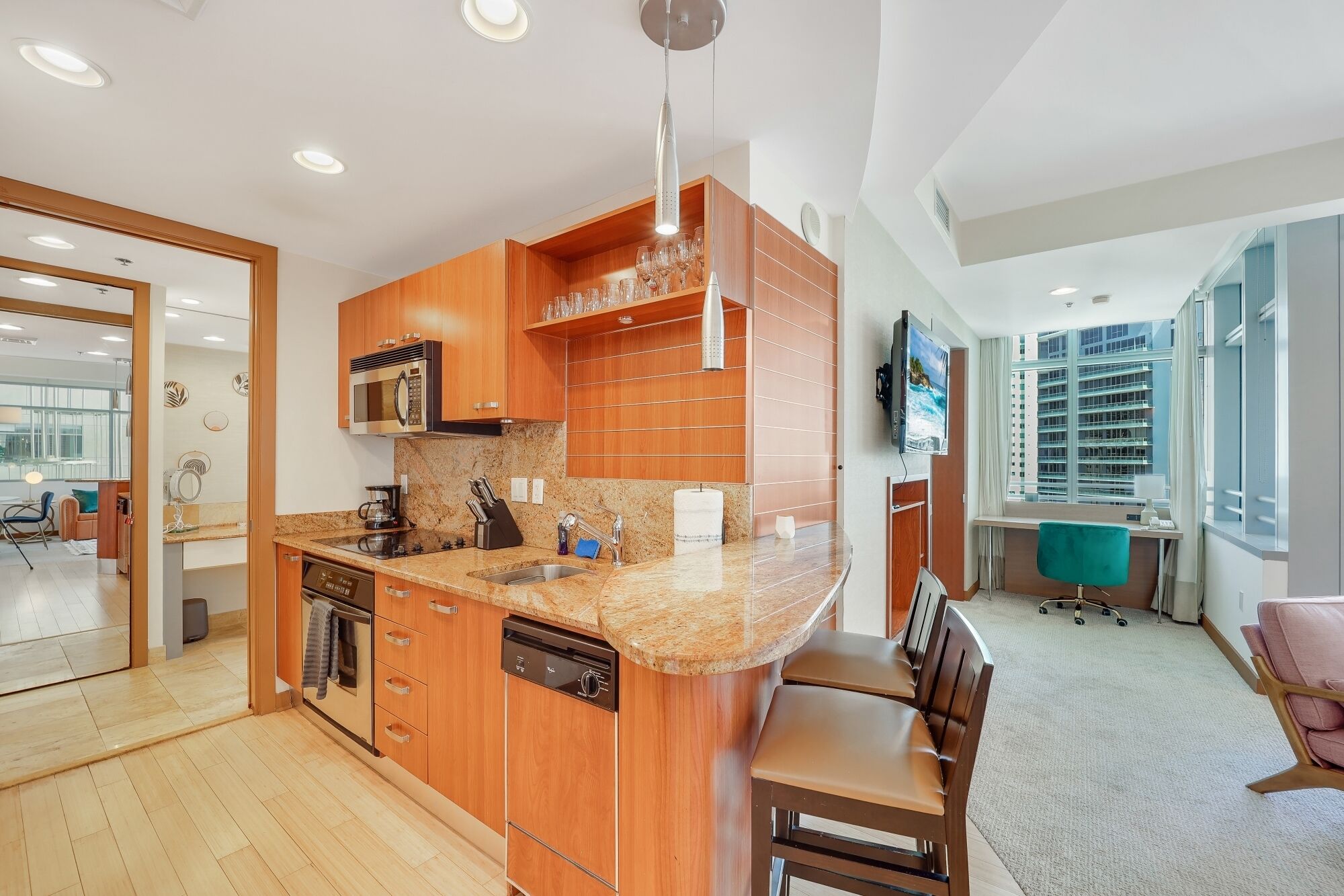 A modern kitchen with wooden cabinets, a granite countertop, and stainless steel appliances.