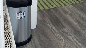 Une cuisine moderne avec des meubles blancs, un réfrigérateur en acier inoxydable, un lave-vaisselle et une poubelle.