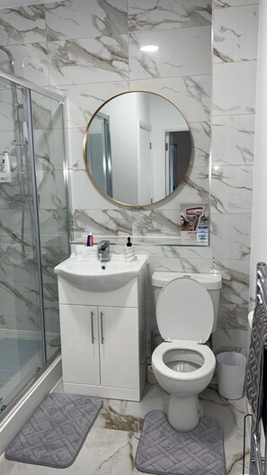 Appartement | Badkamer | Een douche, handdoeken, toiletpapier