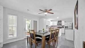 A modern kitchen with white cabinets, a microwave, and a refrigerator. - Pet-Friendly Tulsa Vacation Rental w/ Sunroom (Tulsa)