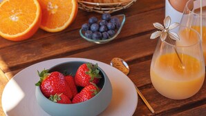 A breakfast setting with croissants, strawberries, blueberries, and orange juice on a wooden table. - Le Mini - Un Voyage en Provence (Aix-en-Provence)