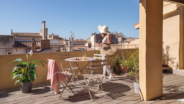A rooftop terrace with a table and chairs, potted plants, and a clear view of the cityscape. - Le Mini - Un Voyage en Provence (Aix-en-Provence)