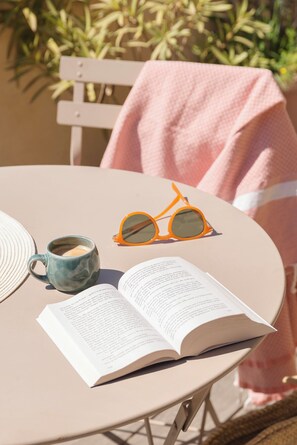A table with a book, a mug, and sunglasses.