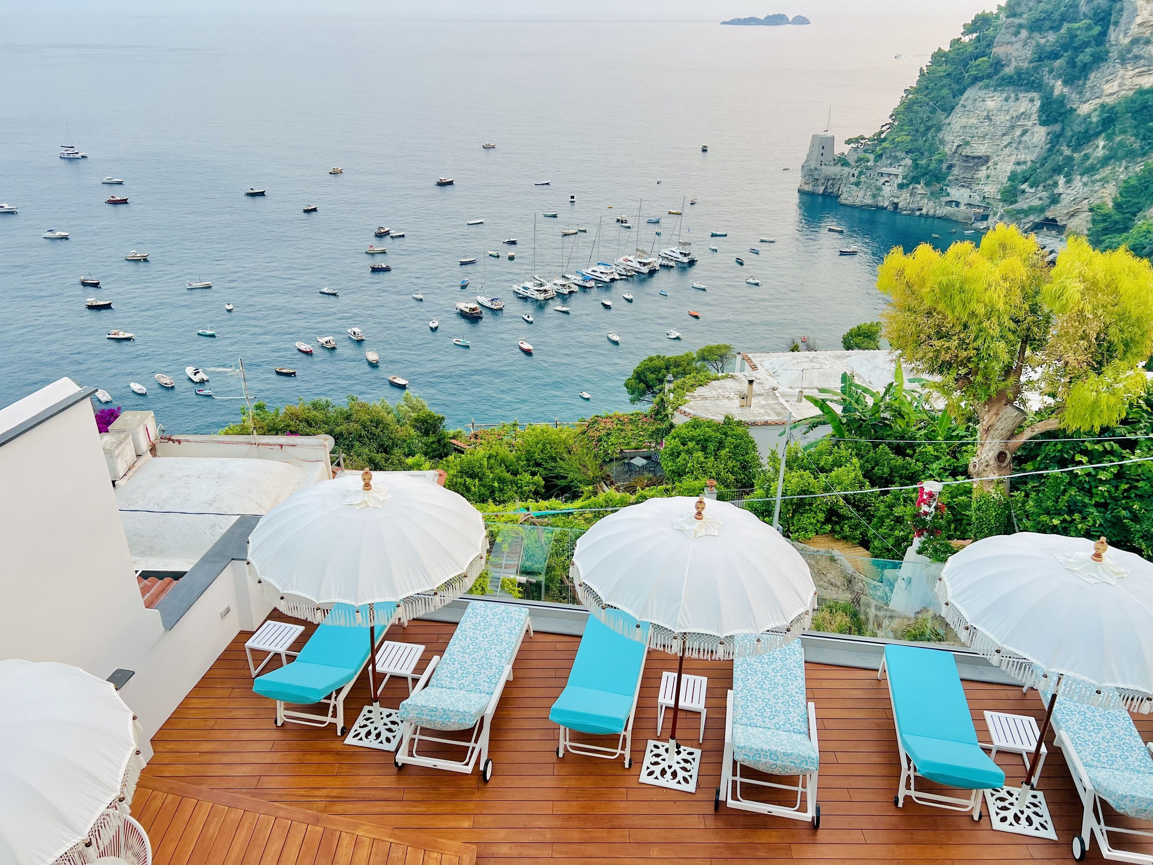 Una piscina al aire libre, sombrillas, sillones reclinables de piscina