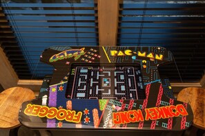 Una máquina recreativa de Pac-Man con una pantalla colorida y las palabras “PAC-MAN” y “DENGEKER” a la vista.