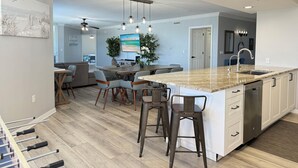 A spacious kitchen with a large island, bar stools, and a dining area. - DestinWest 3Bd Amenities Galore Free Beach Service (Fort Walton Beach)