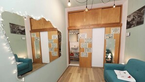 A room with a teal sofa, a wooden cabinet, a mirror, and a small table with a lamp. - Terrace In The Historic Center In Palermo Rosa (Palermo)