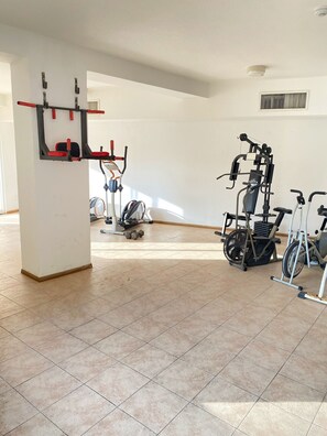 A spacious gym with various exercise equipment, including a pull-up bar, a stationary bike, and a treadmill. - Miramar Vicino al Mare Conosci Goditi Isla Mgt (Mariño)