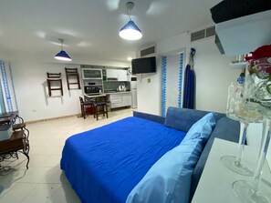 A bedroom with a large bed, a desk, and a kitchenette. - Miramar Vicino al Mare Conosci Goditi Isla Mgt (Mariño)