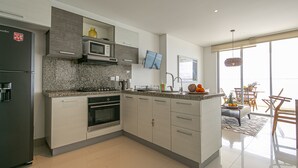 A modern kitchen with a built-in oven, microwave, and granite countertop. - Palmetto Beach 1402 & Sea View - Hot Water- 2bth (Cartagena)