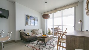 A modern living room with a sofa, coffee table, and dining area. - Palmetto Beach 1402 & Sea View - Hot Water- 2bth (Cartagena)