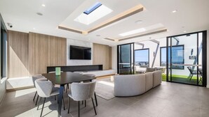 Un salon moderne avec un coin repas, de grandes fenêtres et une vue sur la ville.