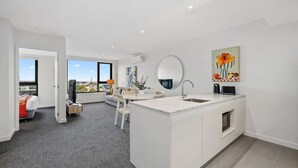 Un appartement moderne doté d’un grand espace de vie, d’une cuisine avec un îlot central et d’un coin repas.