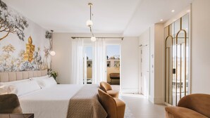 A modern bedroom with a large bed, a seating area, and a mural on the wall. -  MASANET Emblematic Hotels by Airnest (Las Palmas de Gran Canaria)