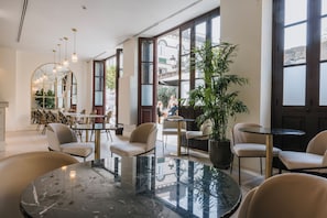 Un intérieur moderne avec des tables rondes, des chaises et un grand miroir.