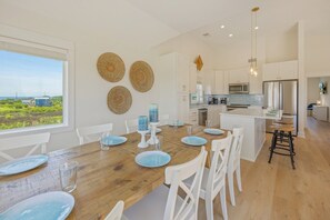 A modern kitchen with white cabinets, a stainless steel refrigerator, and a built-in microwave.