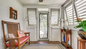 A room with a wooden bench, a door with shutters, a small shelf with dishes, and a potted plant. - Fort Lauderdale Oasis w/ Pool ~ 2 Mi to Beach! (Fort Lauderdale)