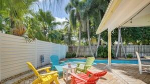 A backyard with a pool, colorful Adirondack chairs, and a covered patio area. - Fort Lauderdale Oasis w/ Pool ~ 2 Mi to Beach! (Fort Lauderdale)