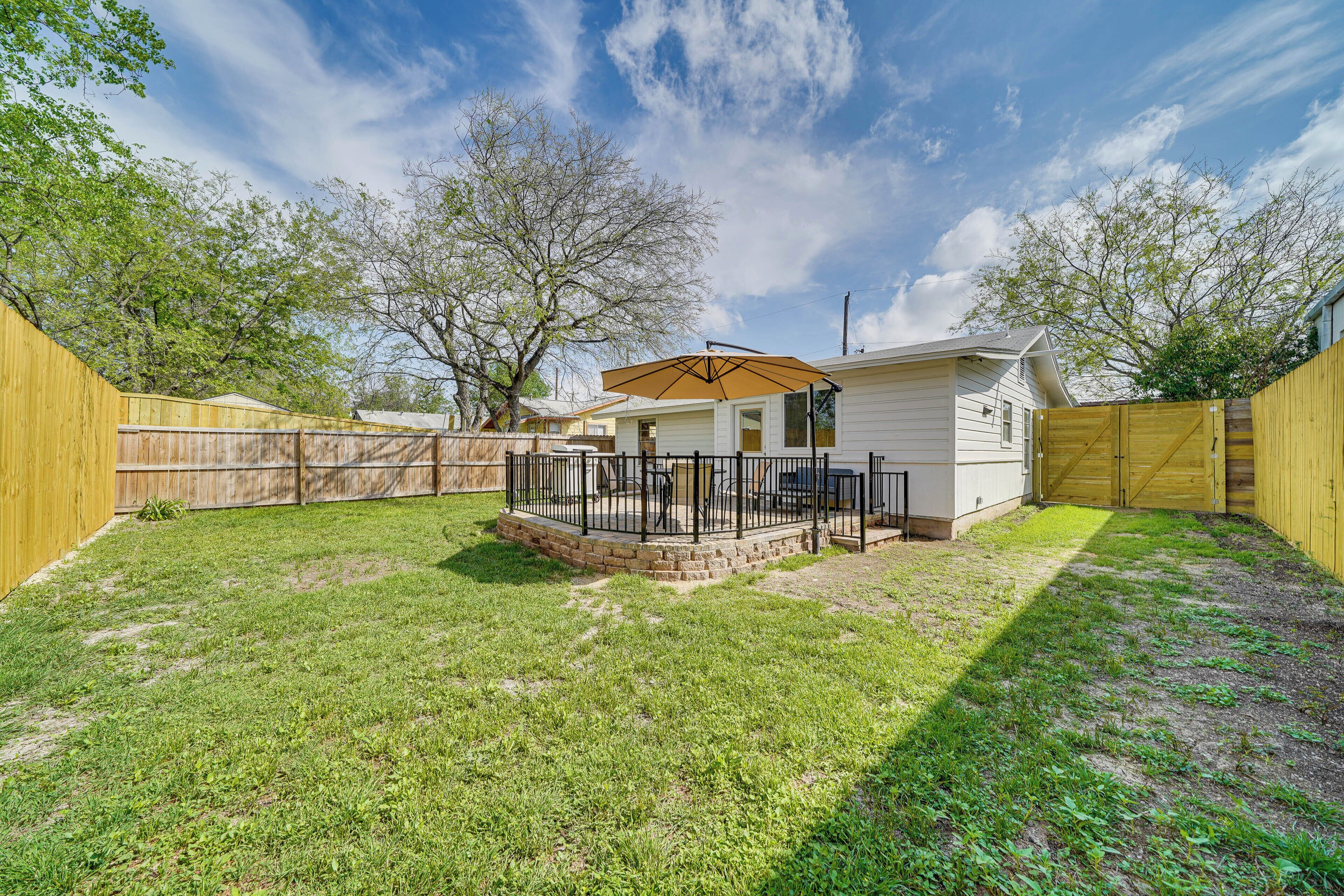 A mobile home with a fenced backyard, a patio area, and a covered outdoor seating space.