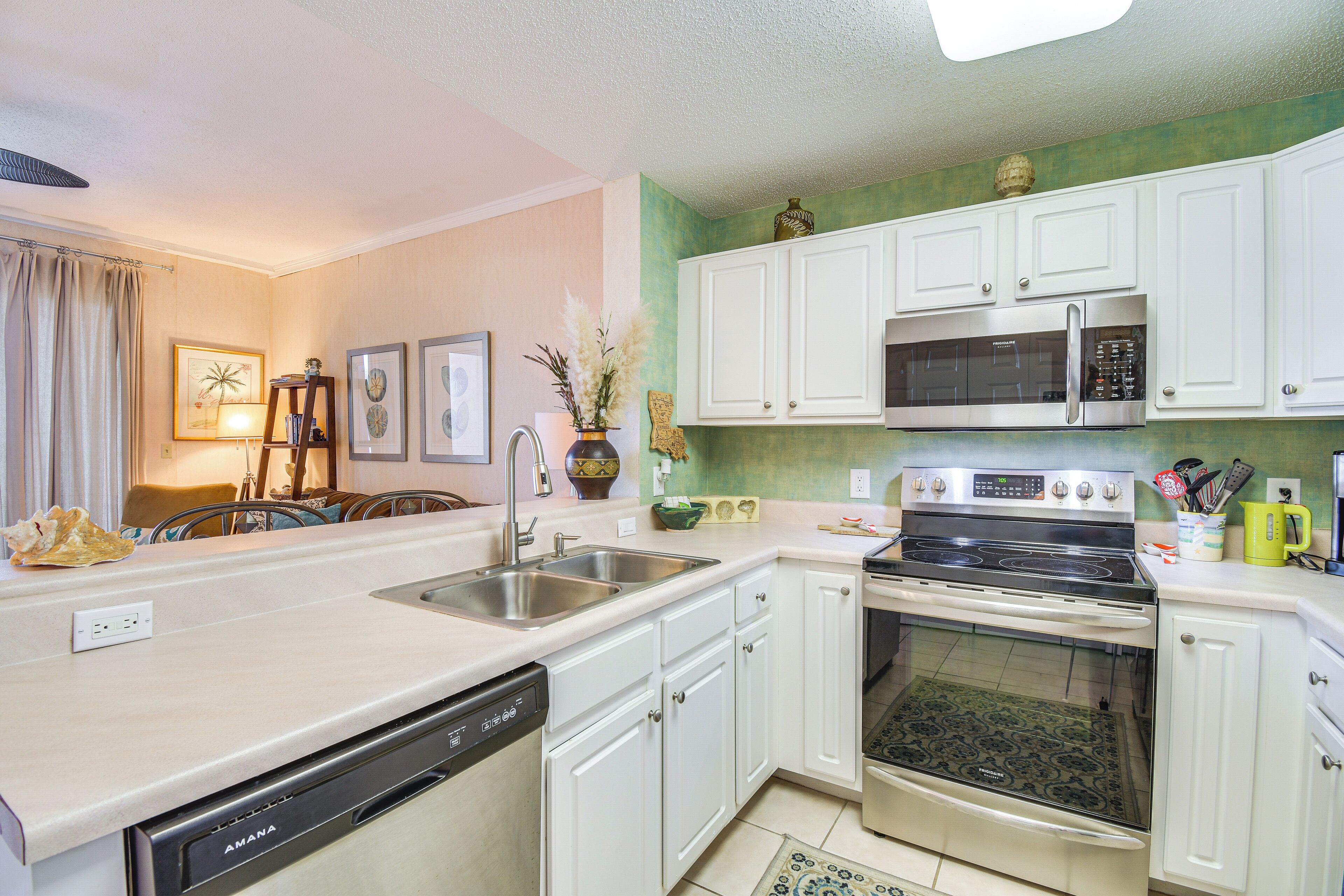 A modern kitchen with white cabinets, stainless steel appliances, and a dishwasher.