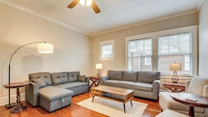 A living room with two grey sofas, a wooden coffee table, and a floor lamp.