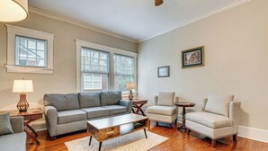 A living room with a grey sofa, a beige armchair, a wooden coffee table, and a small side table with a lamp.