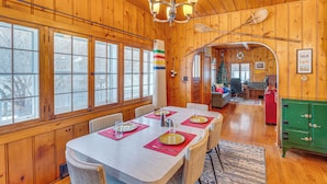 A wooden interior with a dining table set for four, a green cabinet, and a Christmas tree in the background. - Lakefront Getaway w/ Several Extra Amenities (McFarland)