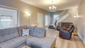 A living room with a gray sectional sofa, a brown leather recliner, and a wooden coffee table. - Peaceful Shiloh Home w/ Deck & Fishing Pond Access (Greenwich)