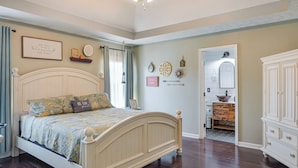 Une chambre à coucher avec un lit, une commode et une coiffeuse.