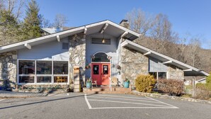 A stone building with a red door, large windows, and a parking lot. - Maggie Valley Studio: 6 Mi to Cataloochee Ski Area (Maggie Valley)