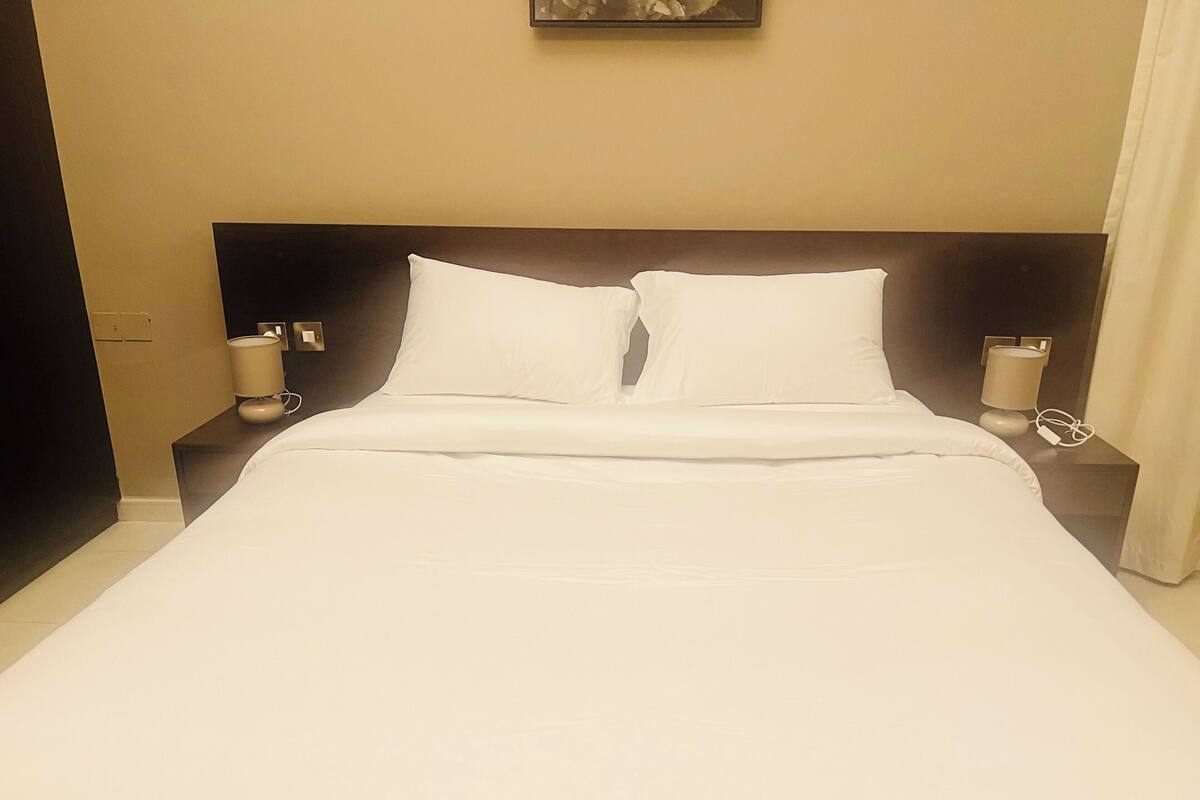 Ein ordentlich bezogenes Bett mit weißen Leinen in einem Hotelzimmer.
