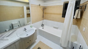 A modern bathroom with a sink, mirror, bathtub, and shower. - AlRaef Luxury Apartments (Dubai)
