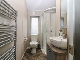 Un baño con inodoro, ducha y lavabo.