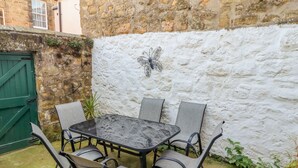 A stone wall with a white textured surface and a decorative metal butterfly. - Victoria House (Alnwick)