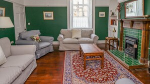 A living room with two sofas, a coffee table, a fireplace, and a large window. - Victoria House (Alnwick)