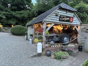 A wooden building with a sign reading 'Fiddlers Green Shop' and 'Est. 1923'.