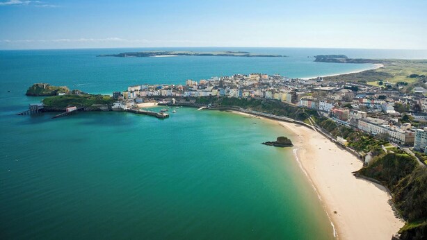 An aerial view of a coastal town with a beach, harbor, and surrounding buildings. - Fiddlers Green Log Cabin, Tenby (Saint Florence)
