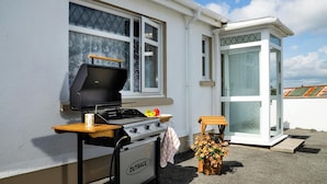 A barbecue grill, a small table, and a flower arrangement outside a house. - 2 Rock Cottage, Llansteffan (Llansteffan)