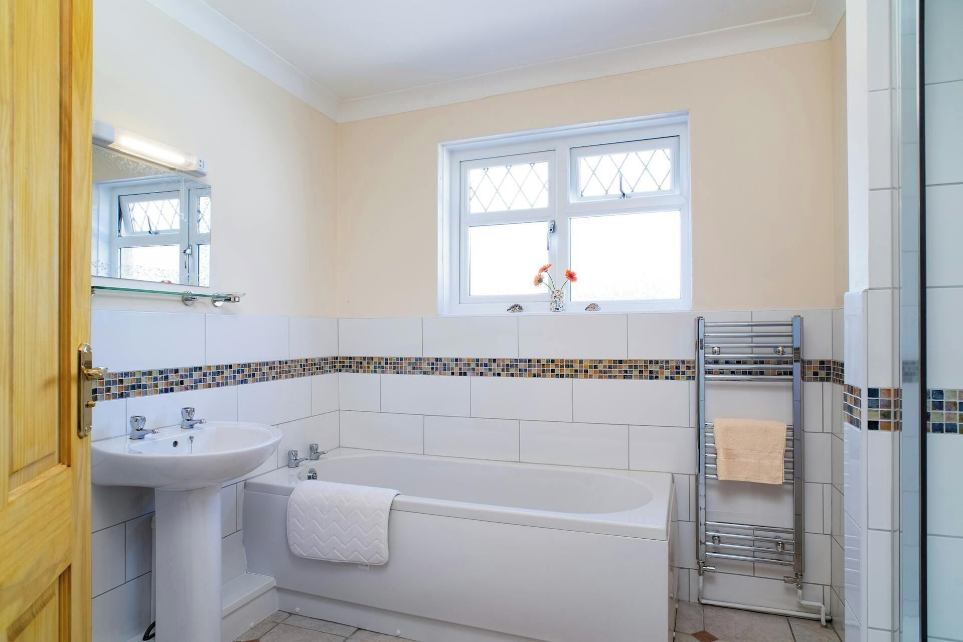 Une salle de bain avec un lavabo, une baignoire et une fenêtre.