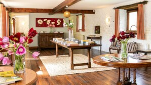 A cozy room with wooden furniture, a round table, and a bookshelf. - Stunning Barn Conversion - Peaceful Retreat (Old Chalford)